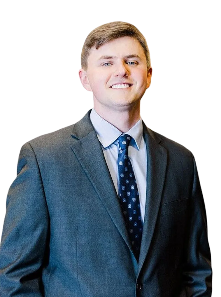 Professional young man with light brown hair wearing a gray suit and patterned navy tie.